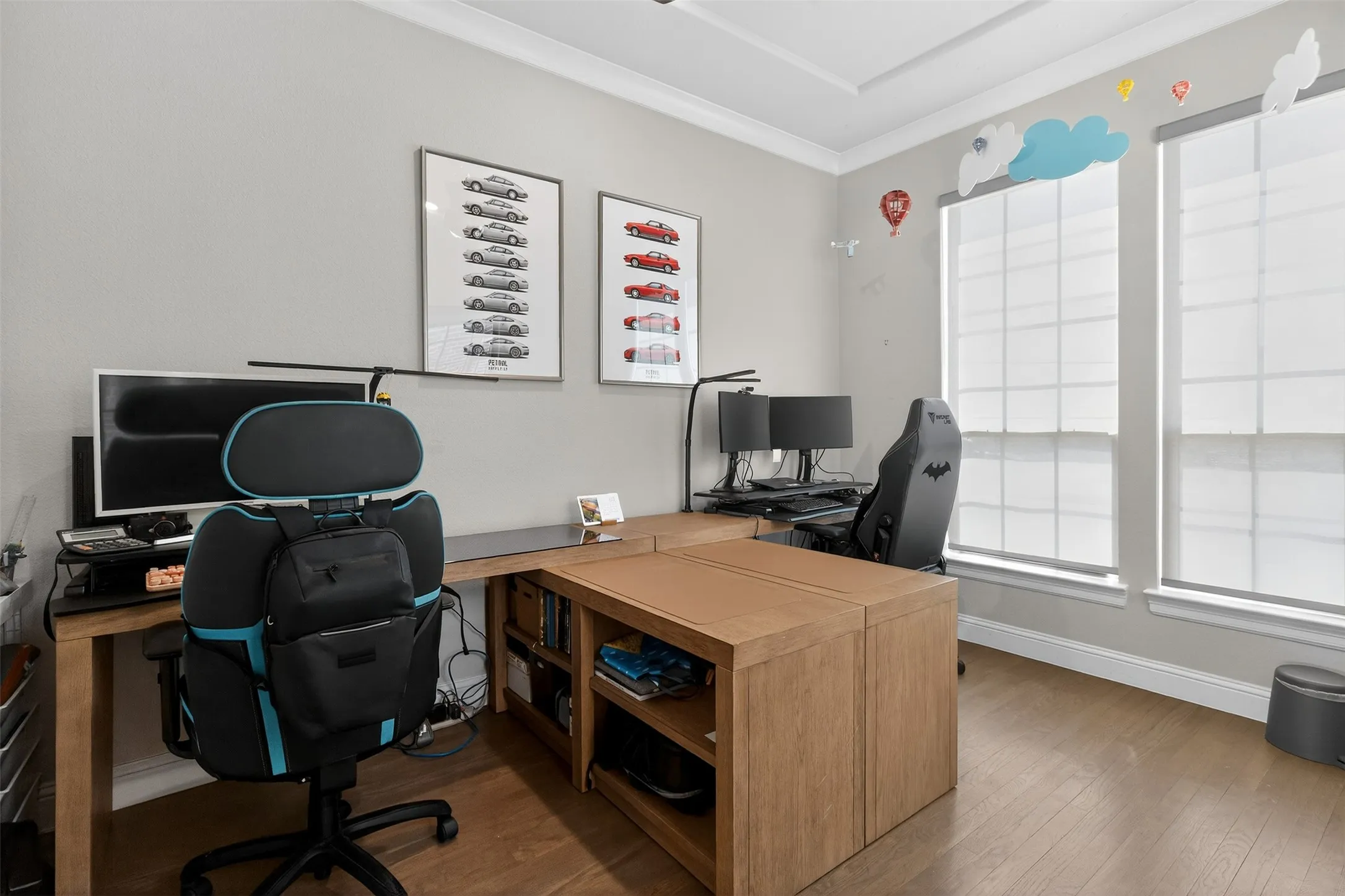 Dedicated workspace featuring wood-finish flooring, light gray wall paint, and a tray ceiling