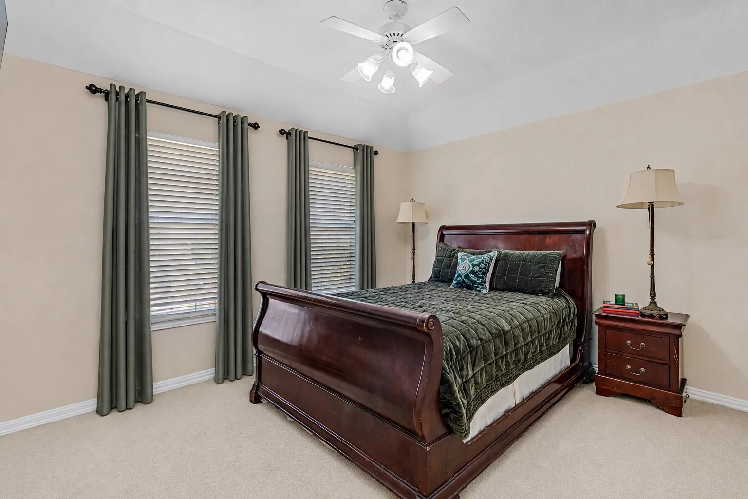 Carpeted room featuring a tray ceiling and a ceiling fan with integrated lighting
