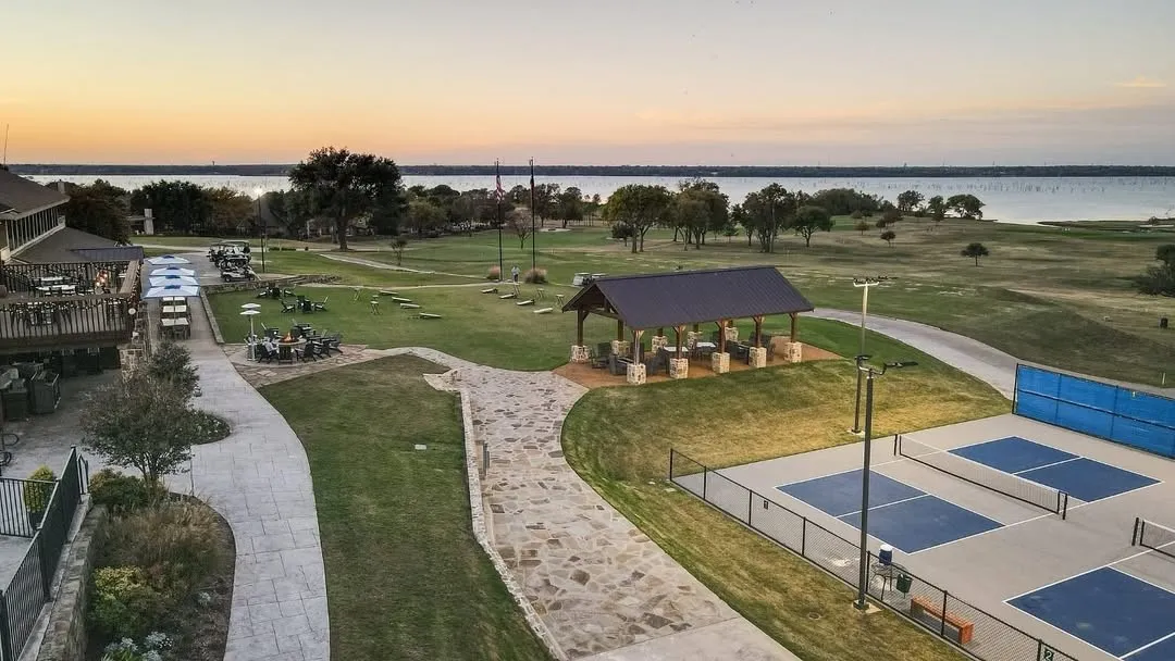 Expansive property featuring multiple pickleball courts, a covered pavilion, and a stone pathway