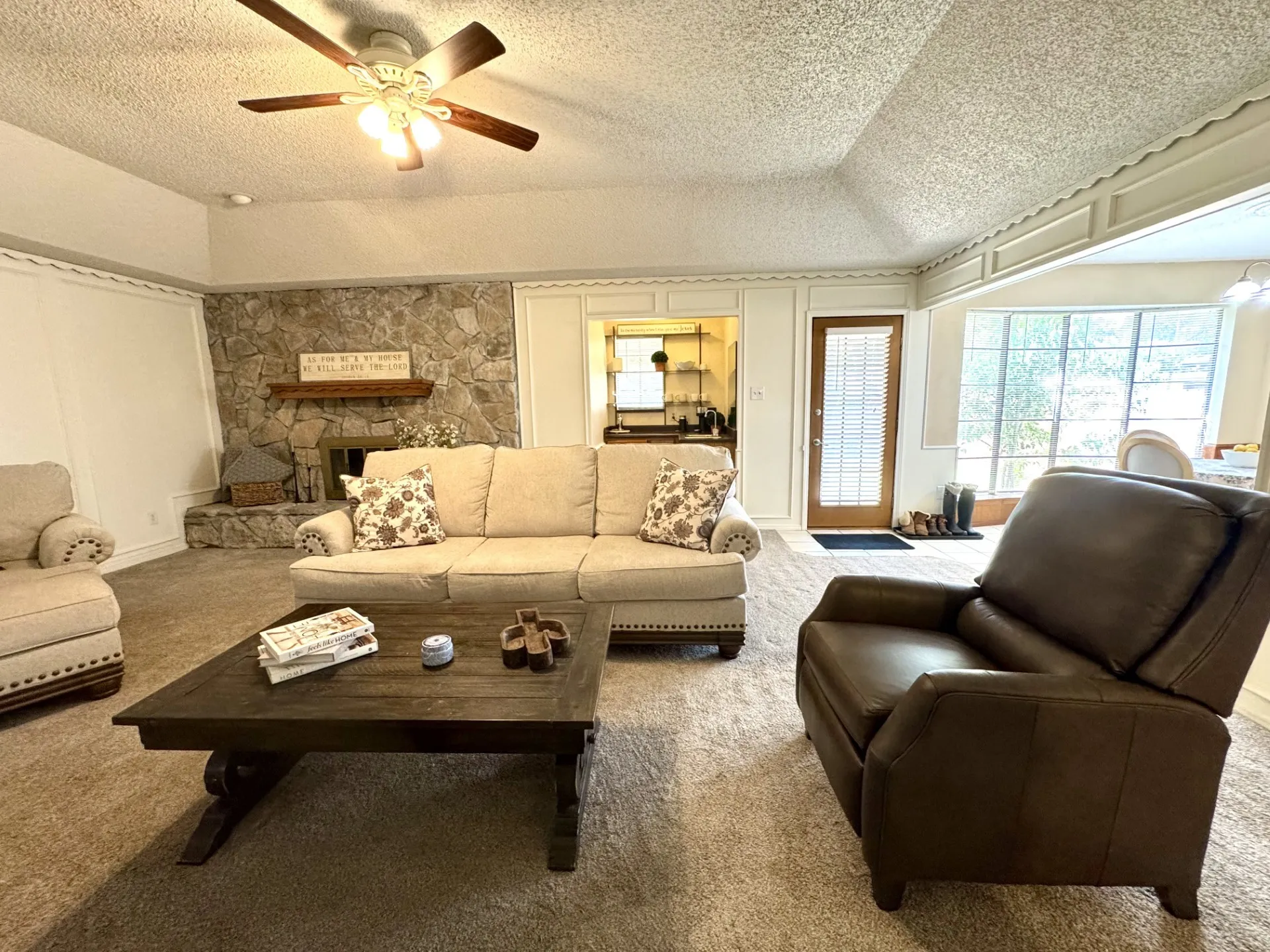 Stone fireplace with a wood mantel, Wet Bar, and Vaulted Ceiling. Nice carpeting too!