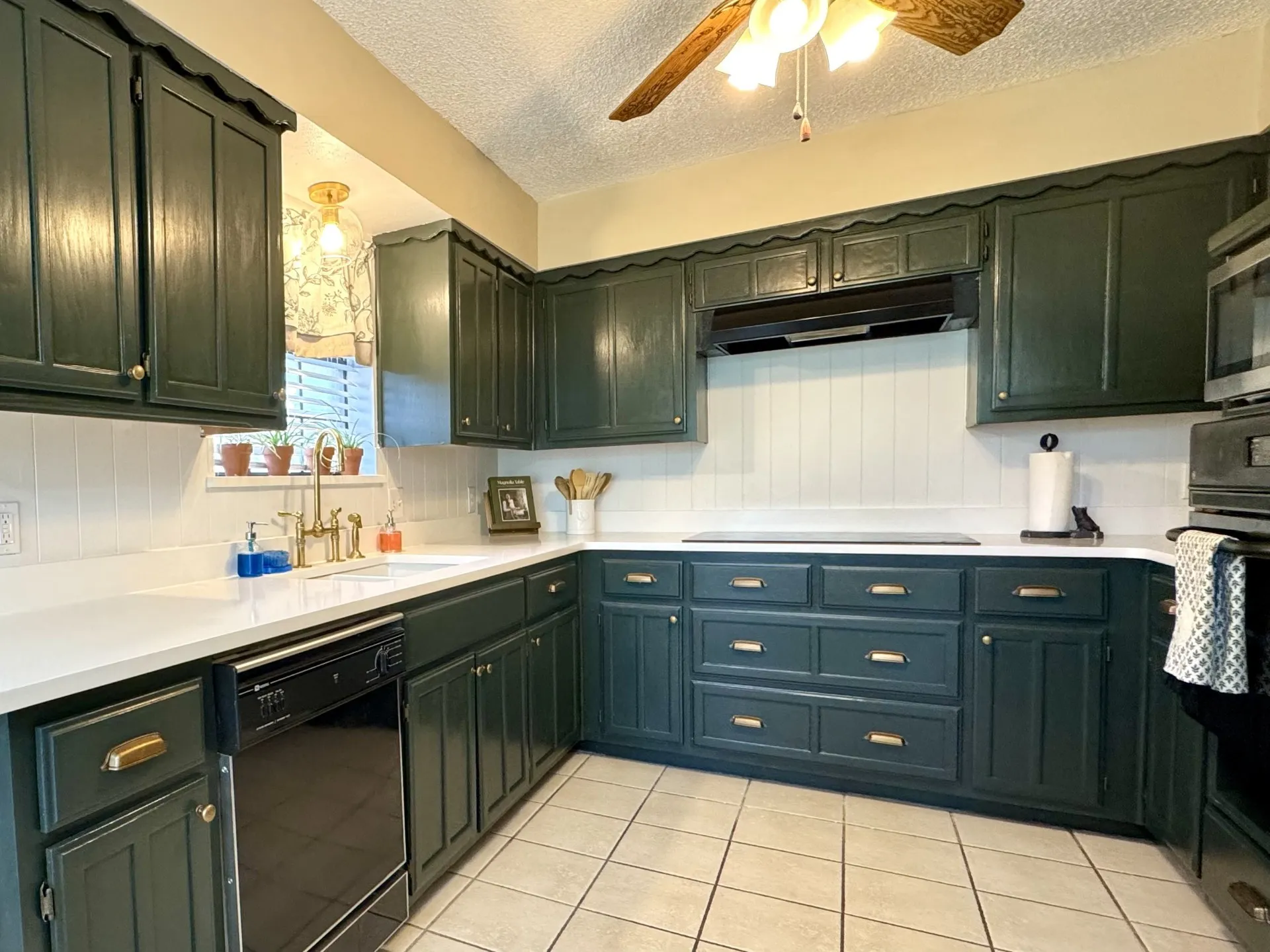 Quartz Countertops with Undermounted Sink / Electric Glass Cooktop: Brass hardware, white beadboard backsplash, and tile floors.