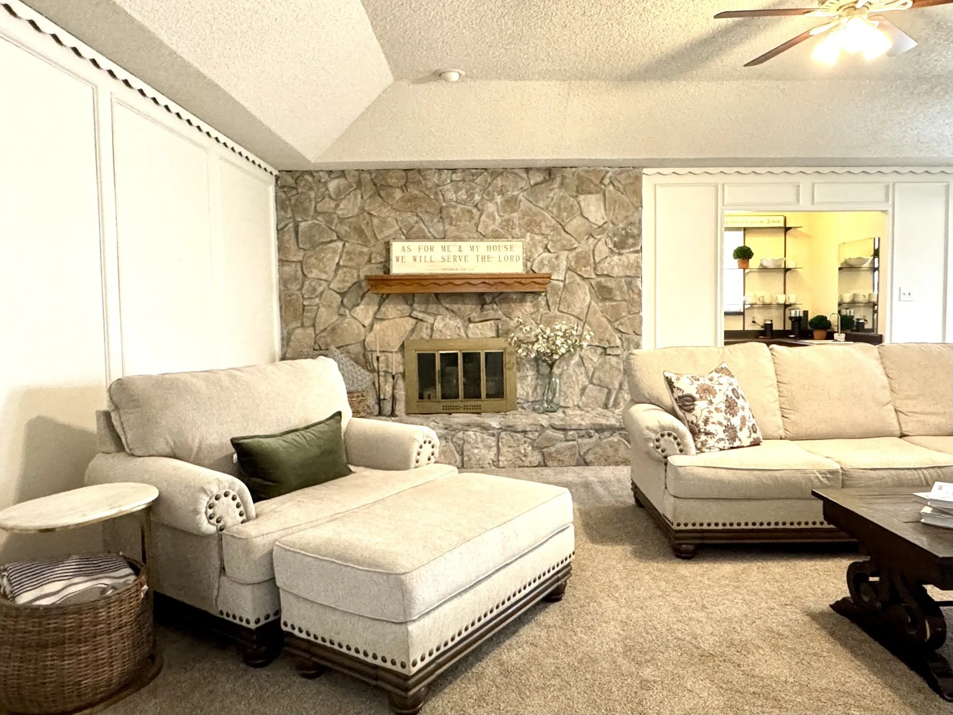 Living area featuring a Stone WOOD-Burning fireplace with a wood mantle, wet bar, and vaulted ceiling with ceiling fan. (Fireplace has gas logs that connect to a propane tank - not shown)