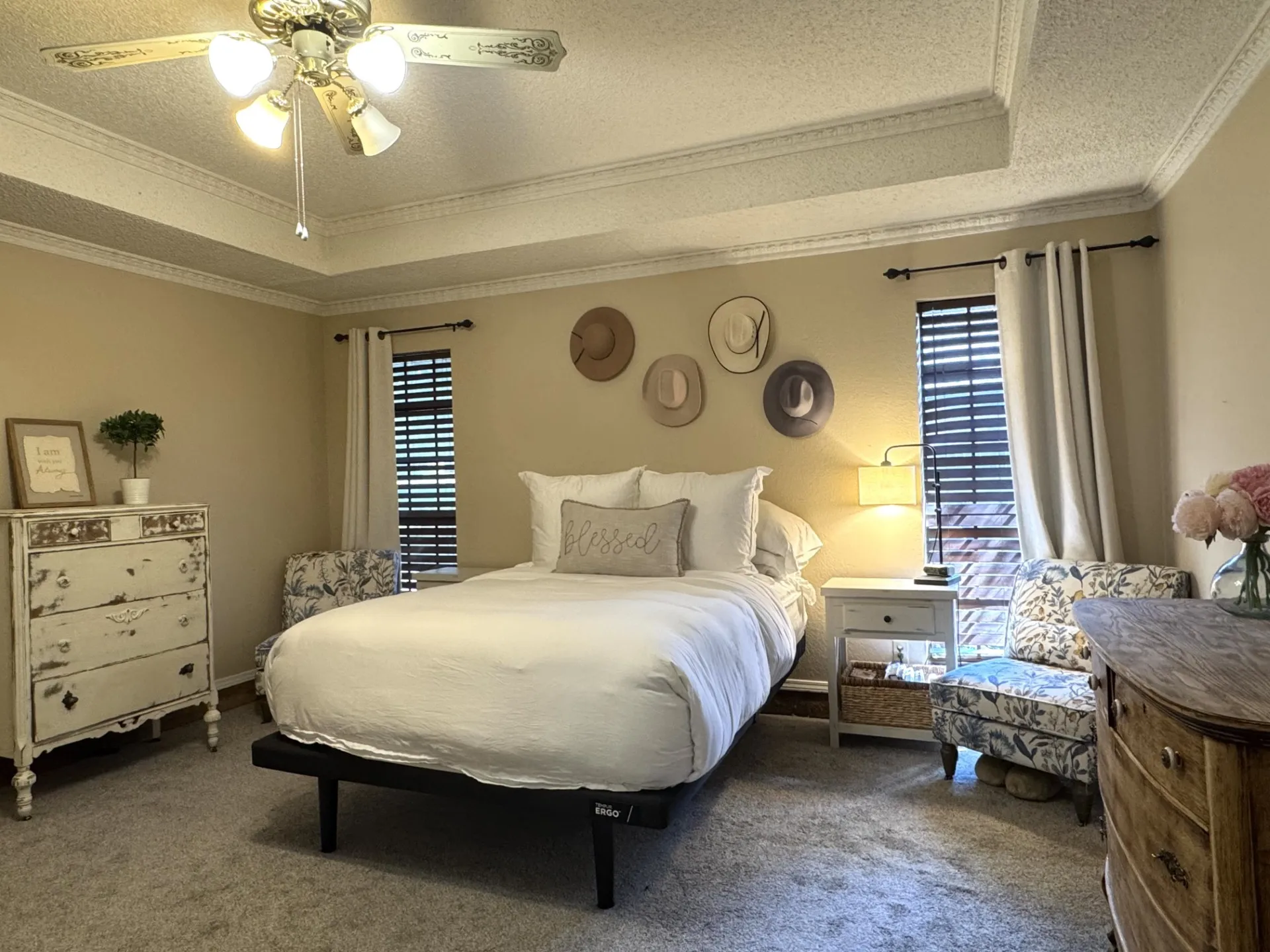 Primary RETREAT is privately SPLIT from other bedrooms... ceiling fan with light fixture, wall-to-wall carpeting, window with blinds and drapes, and neutral wall paint