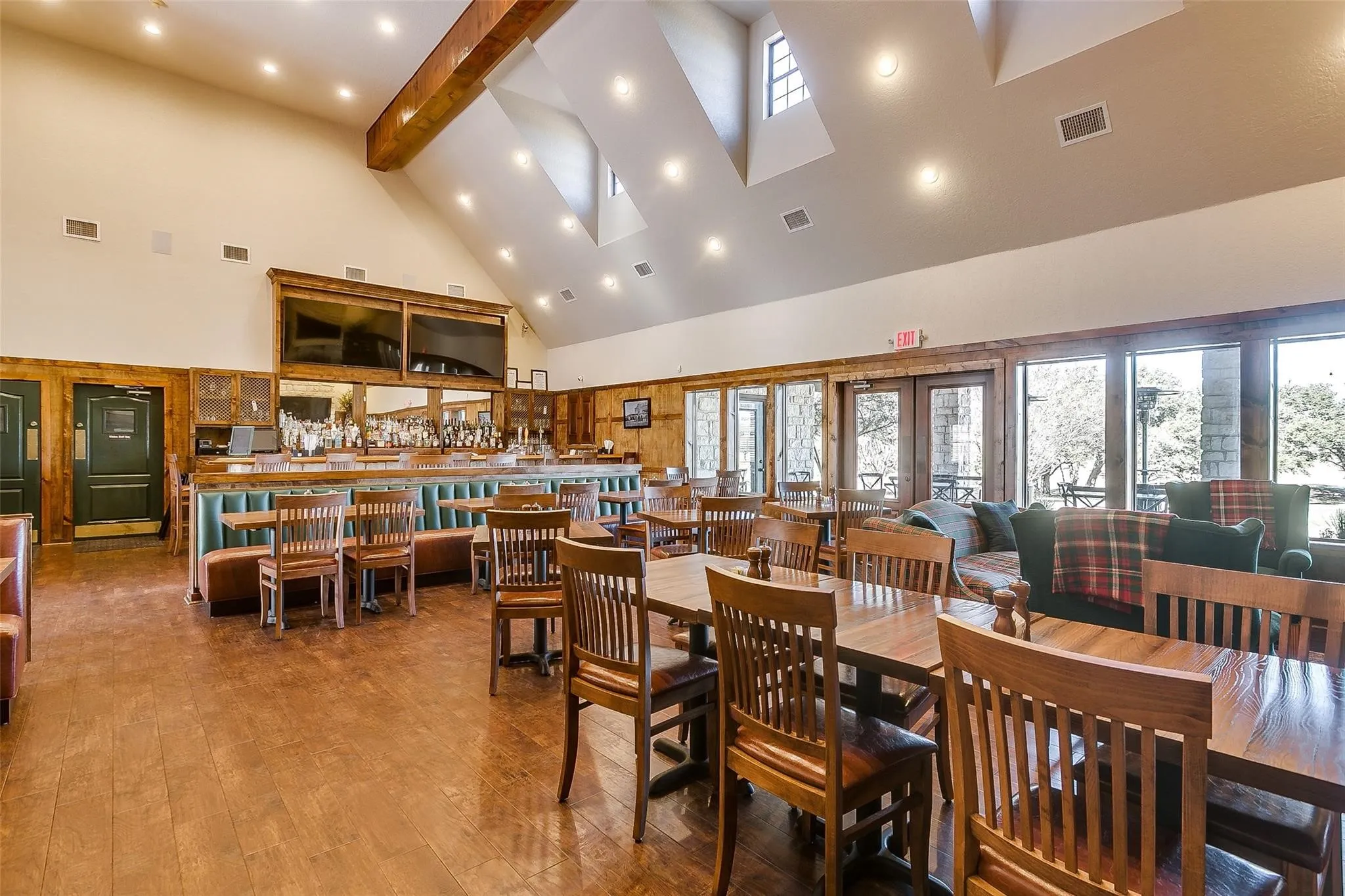 Spacious interior featuring wood-finish flooring, a vaulted ceiling with skylights, and a built-in bar with booth seating