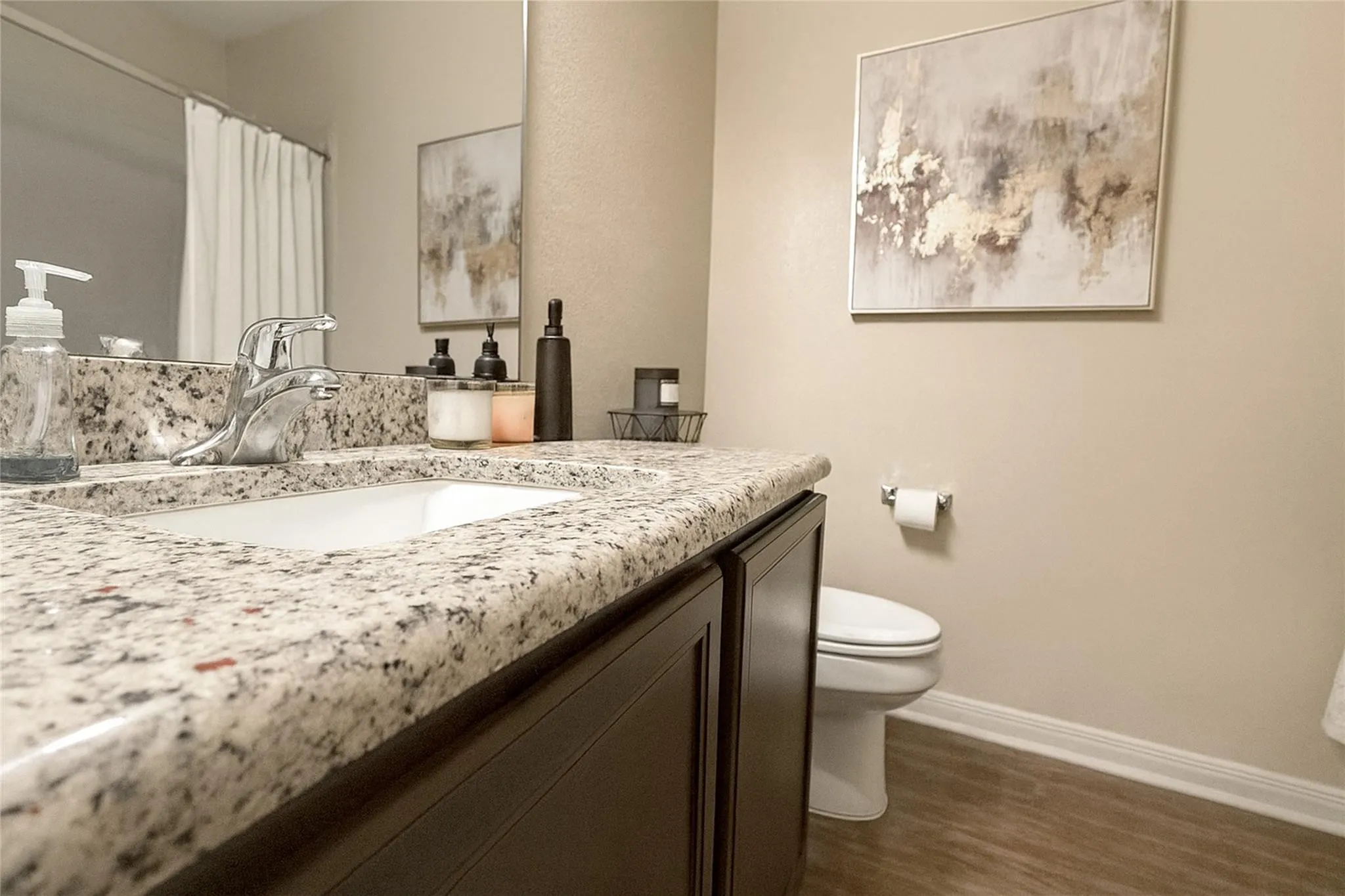 Bathroom vanity featuring a light-toned speckled countertop, an undermount sink, and a chrome faucet
