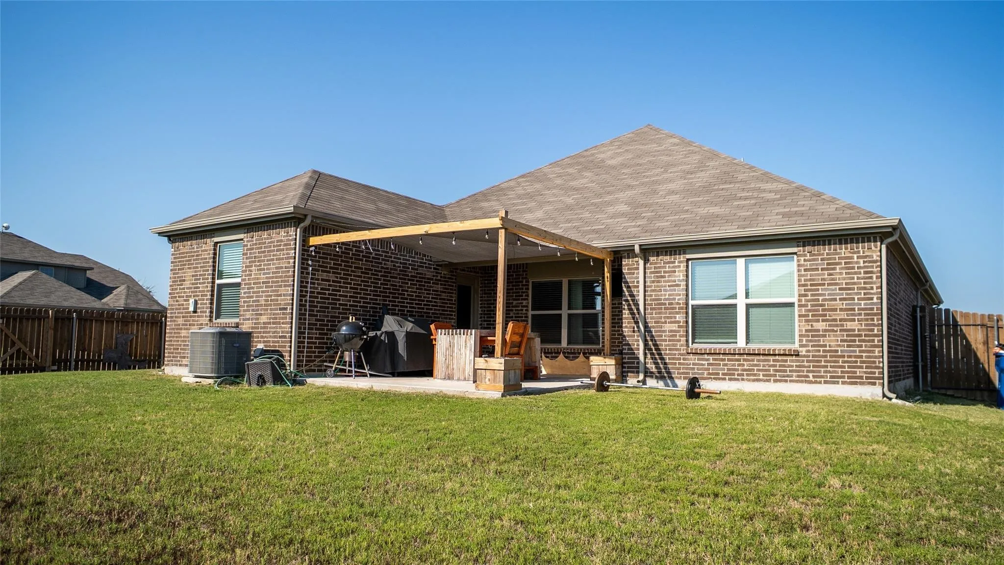 Expansive backyard featuring a manicured lawn and a full brick exterior