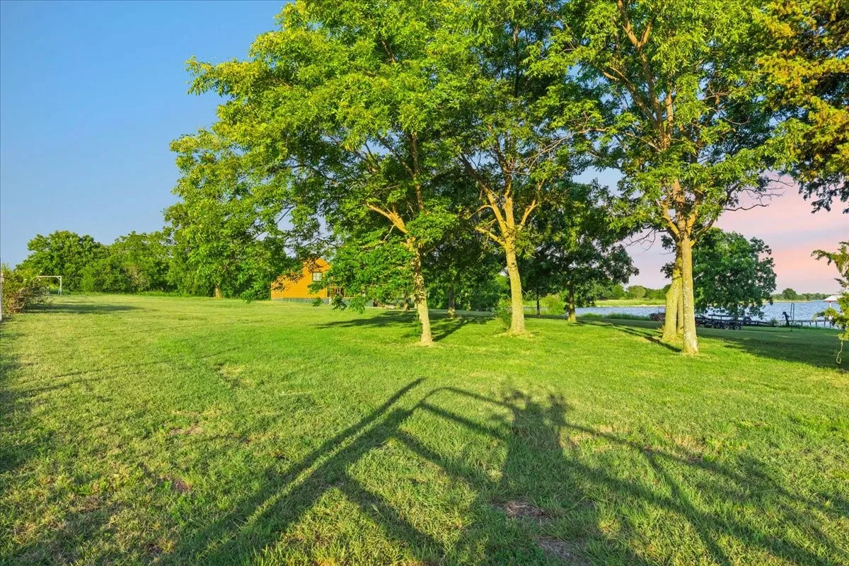 Spacious lawn area with mature trees and waterfront exposure