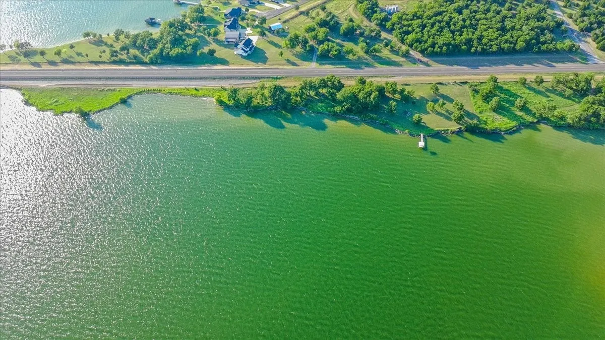 Expansive waterfront property featuring a private dock, lush green landscaping, and direct water access