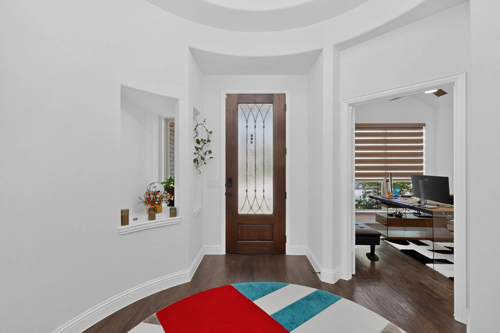 Entryway featuring a decorative wood-finish door with frosted glass inserts, dark wood-finish flooring, and a coved ceiling detail