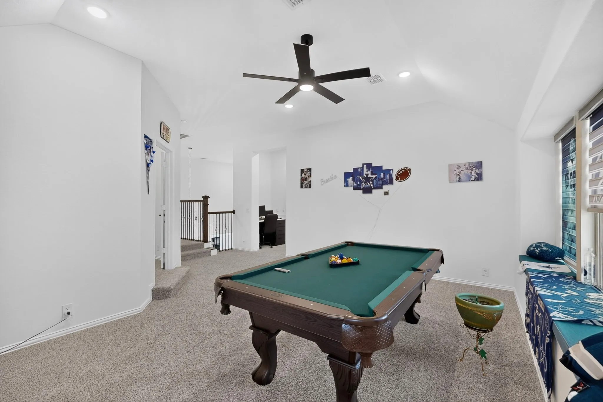 Spacious room with pitched ceiling, recessed lighting, and a modern ceiling fan