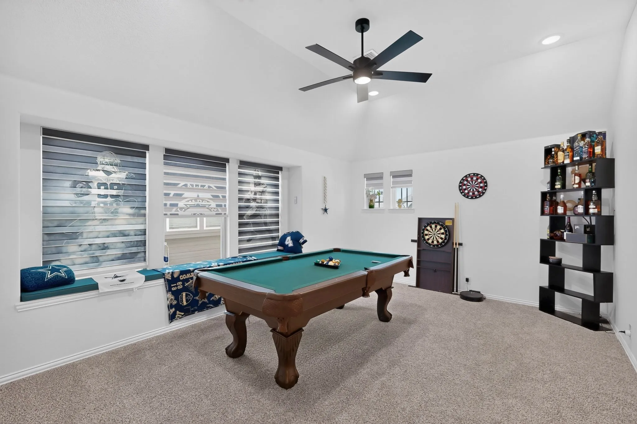 Spacious room featuring vaulted ceilings, recessed lighting, and soft carpet flooring