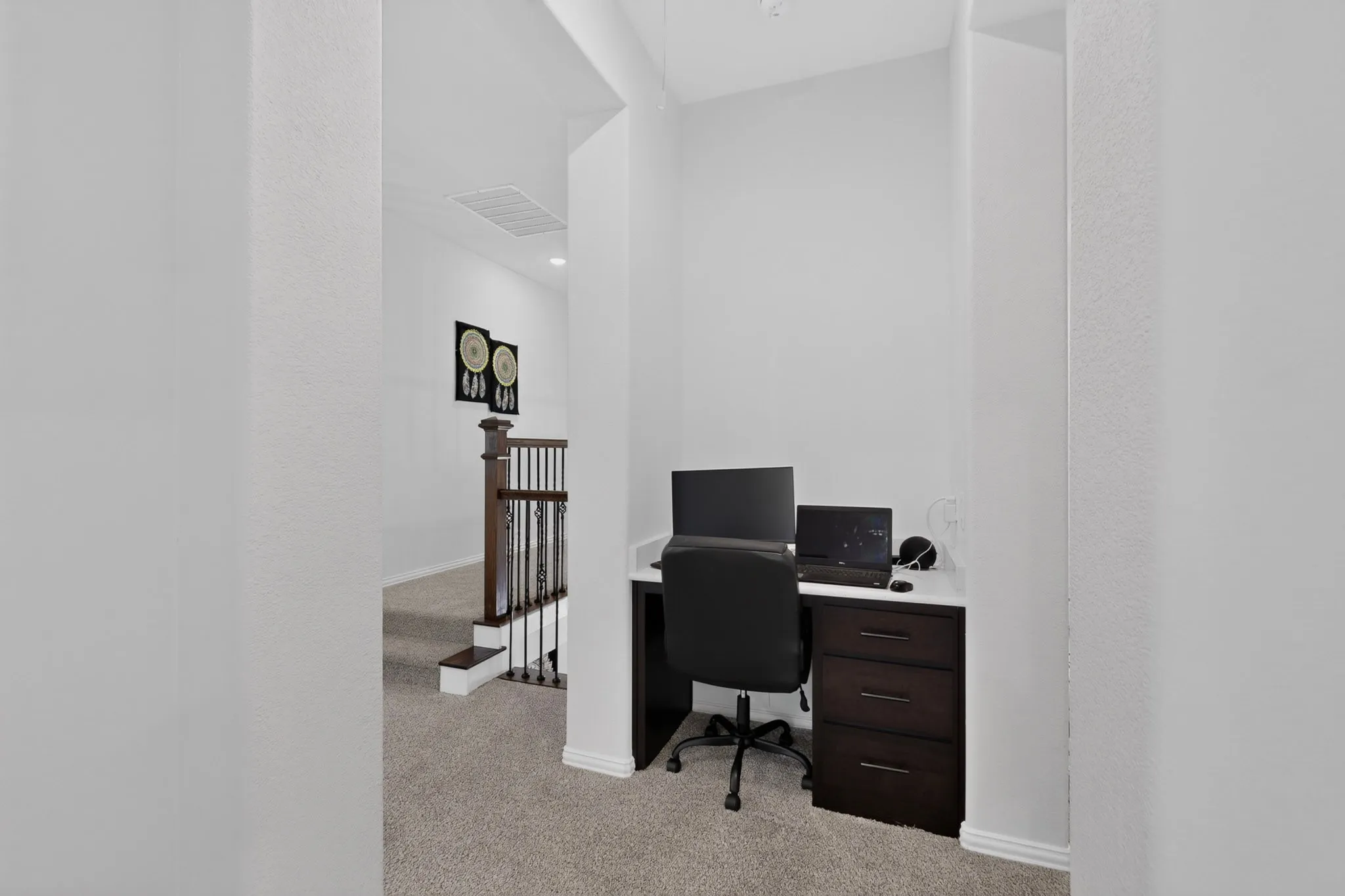 Built-in desk nook with a white countertop and dark wood-finish cabinetry