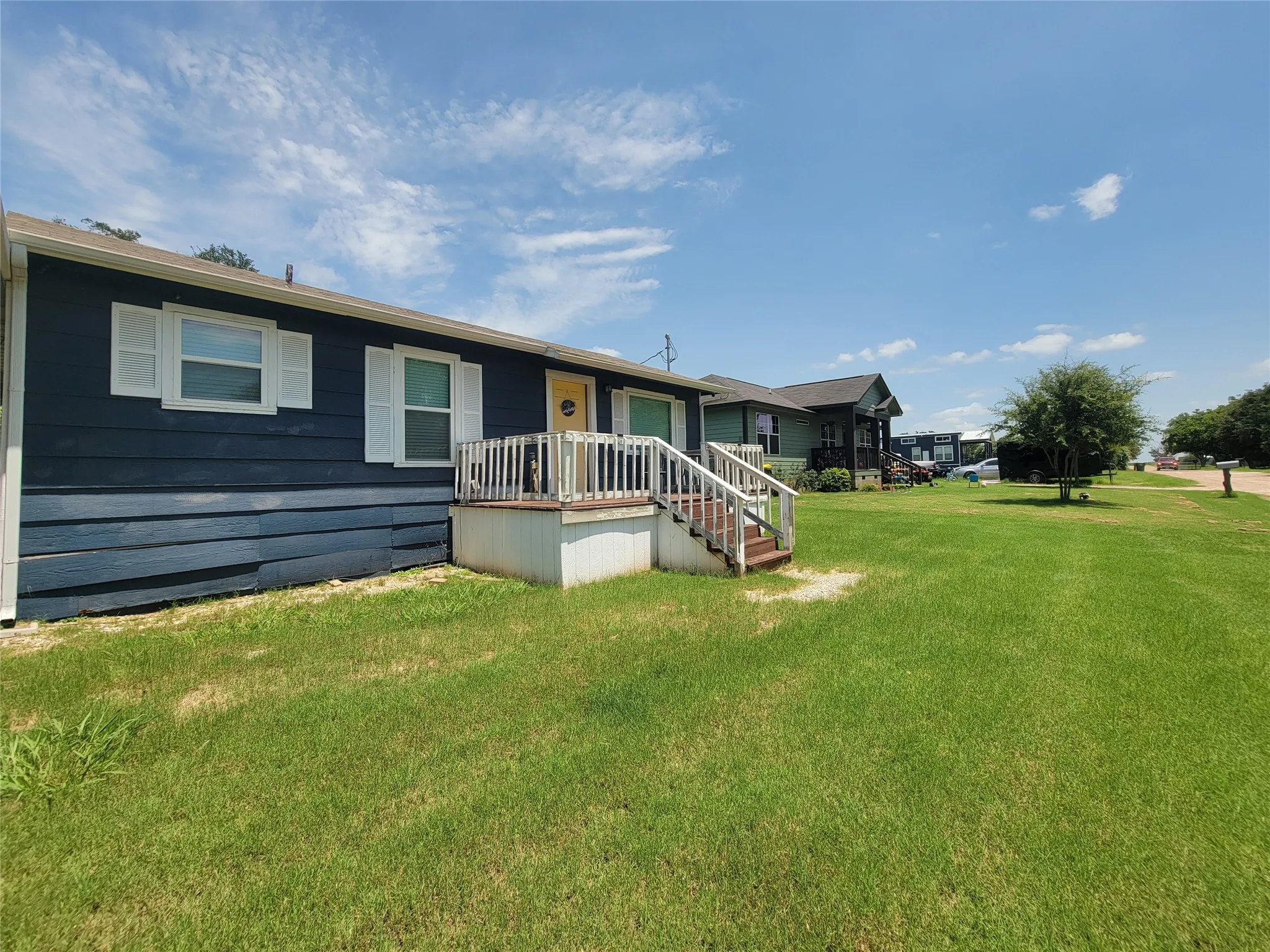 Single-story residence featuring dark blue siding, white trim, and white window shutters