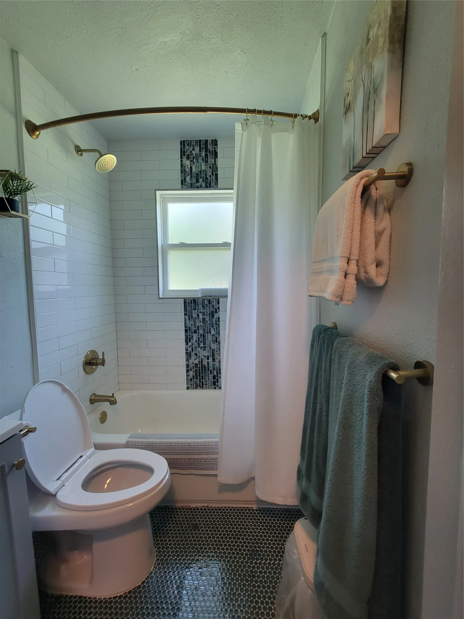 Bathroom featuring a tub/shower combination with white subway tile surround, accent mosaic tile, and a window
