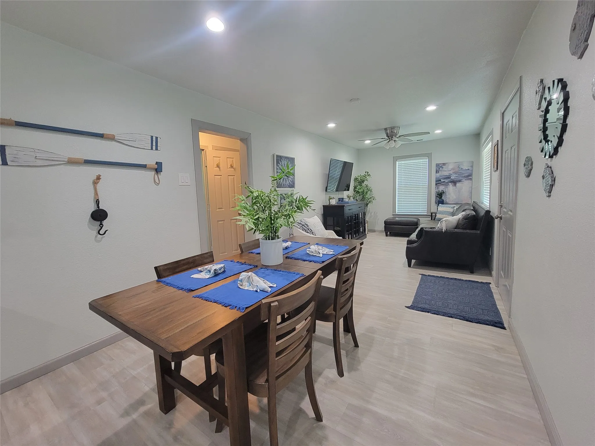 Open-concept living area featuring light wood-finish flooring, recessed lighting, and a ceiling fan