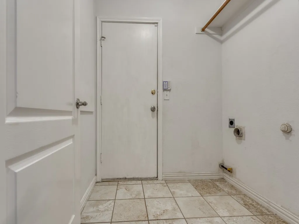 Washroom featuring baseboards, hookup for an electric dryer, laundry area, light tile patterned flooring, and hookup for a gas dryer