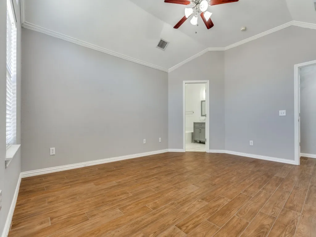 Unfurnished room featuring lofted ceiling, baseboards, visible vents, and light wood finished floors