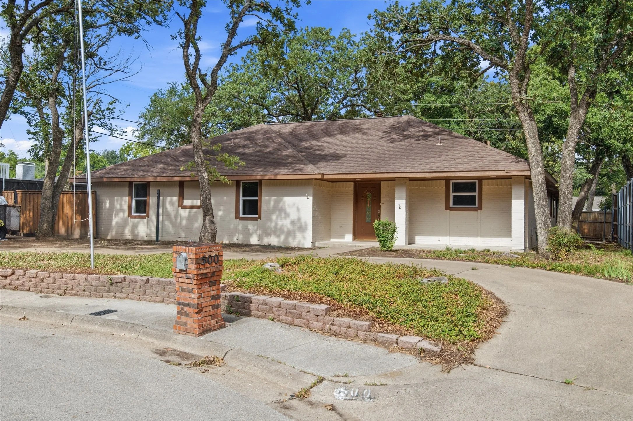 Single-story residence featuring a stucco exterior and a brown shingle roof