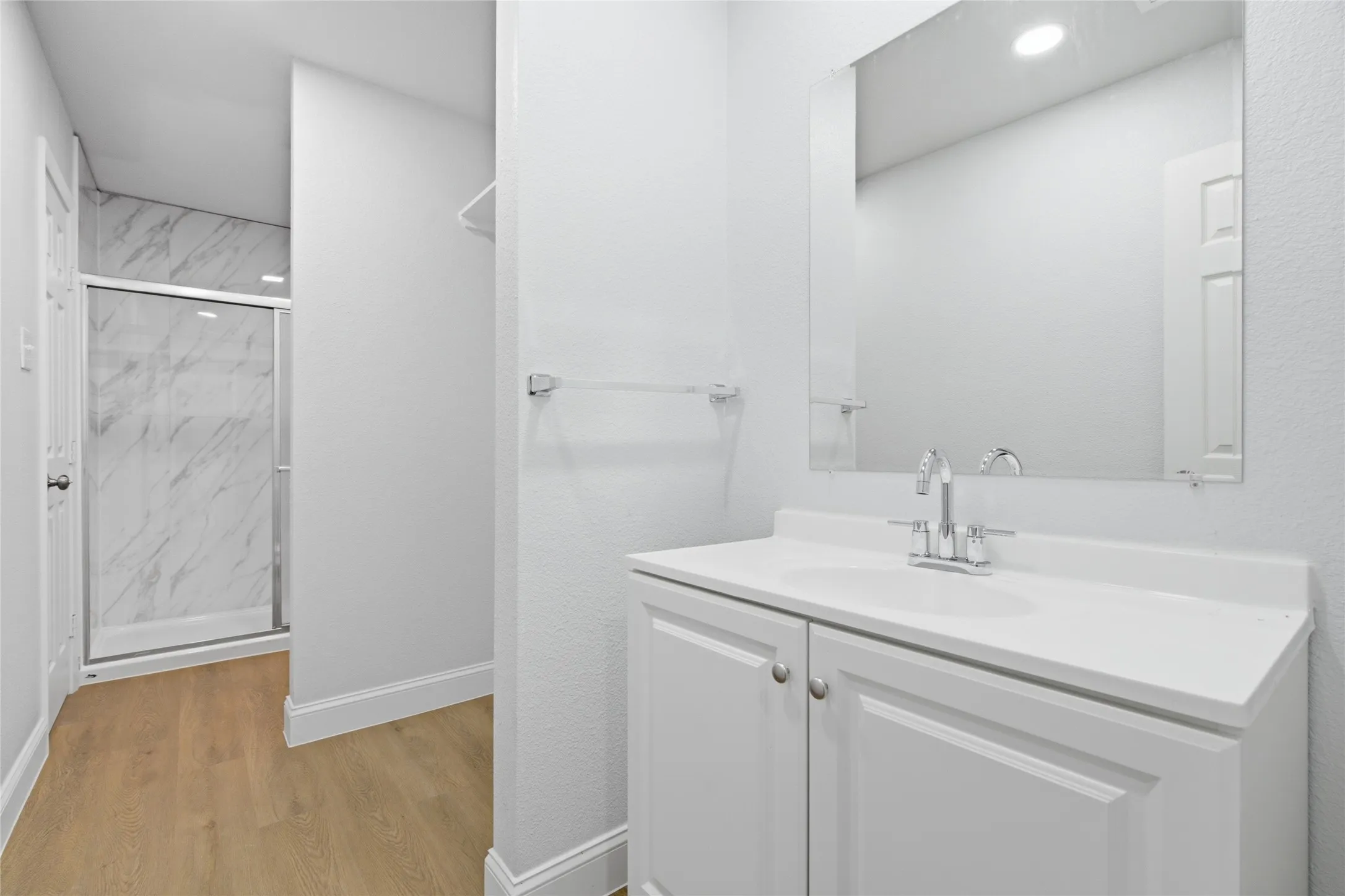 Contemporary bathroom featuring a white vanity with integrated sink, chrome faucet, and a large wall-mounted mirror