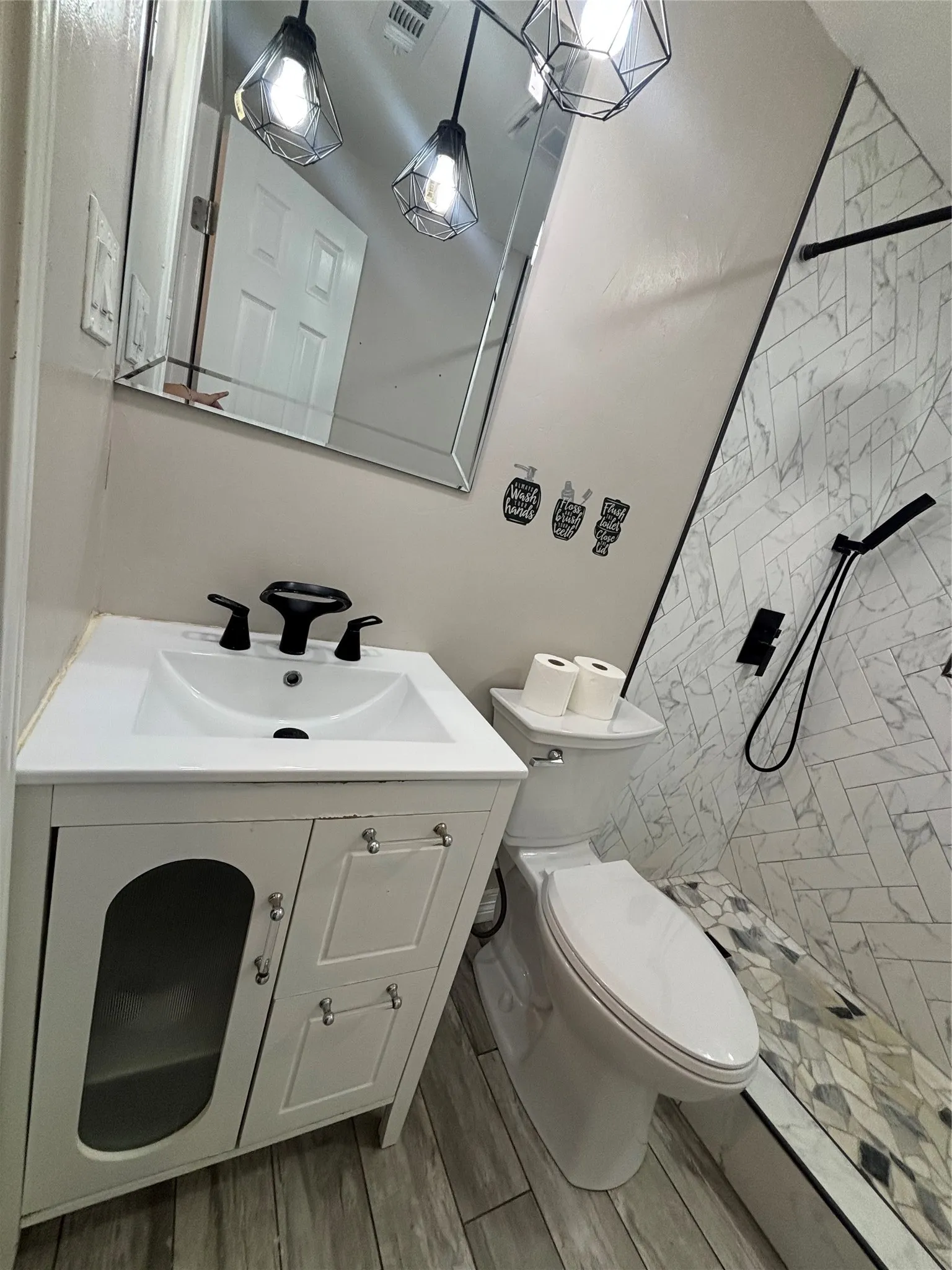 Bathroom featuring a single vanity with storage, tile flooring, and a walk-in shower with herringbone-patterned tile and a built-in bench