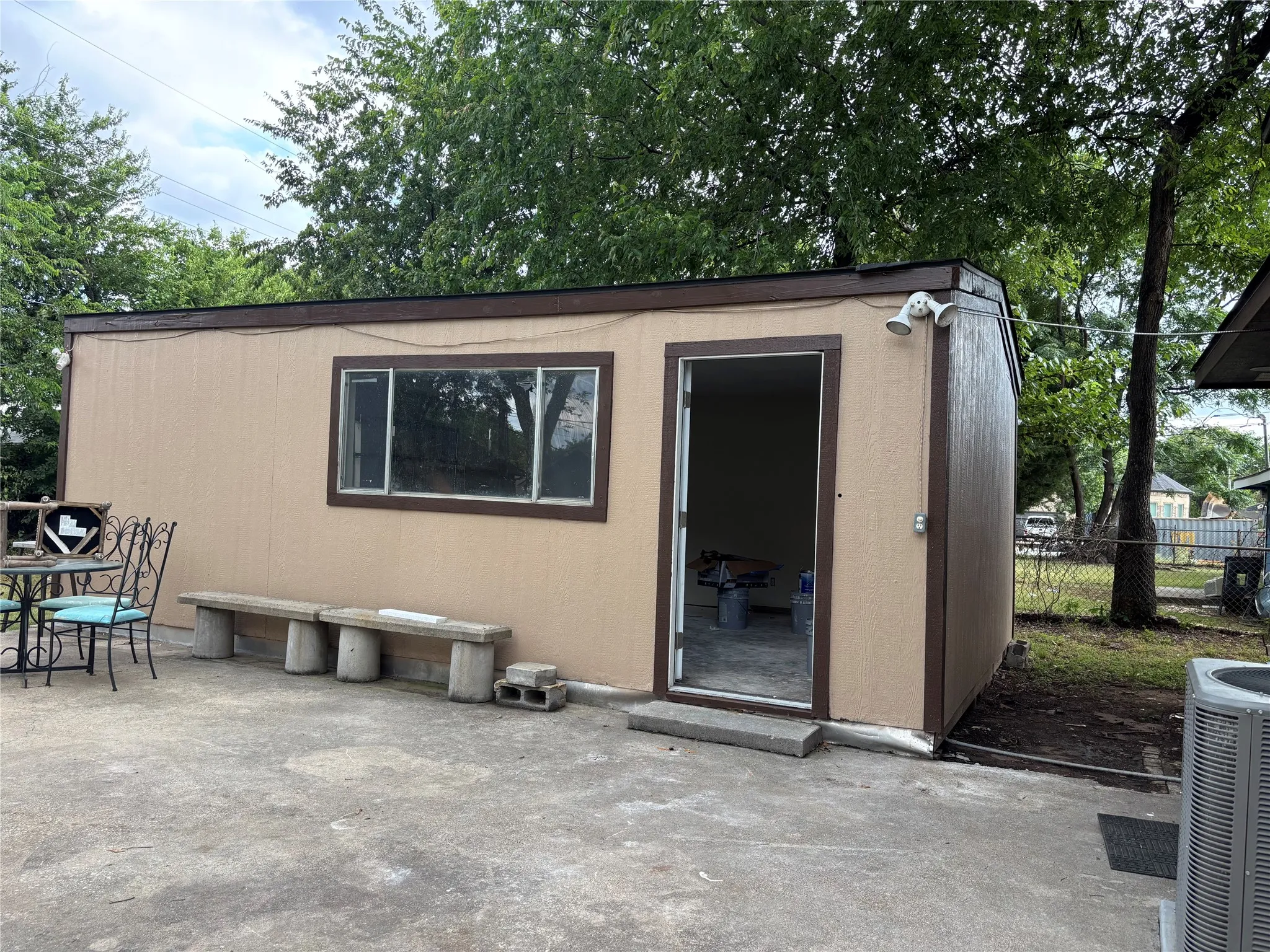 Detached structure with a tan exterior, brown trim, and a flat roof