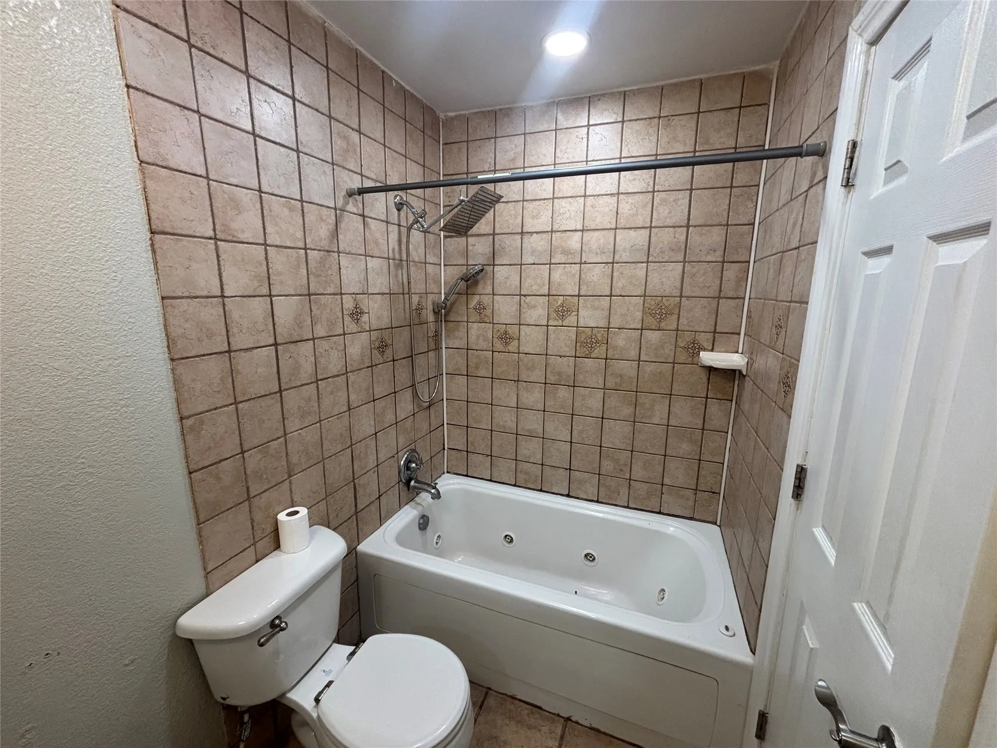 Bathroom featuring a built-in jetted tub and shower combination with a rainfall showerhead