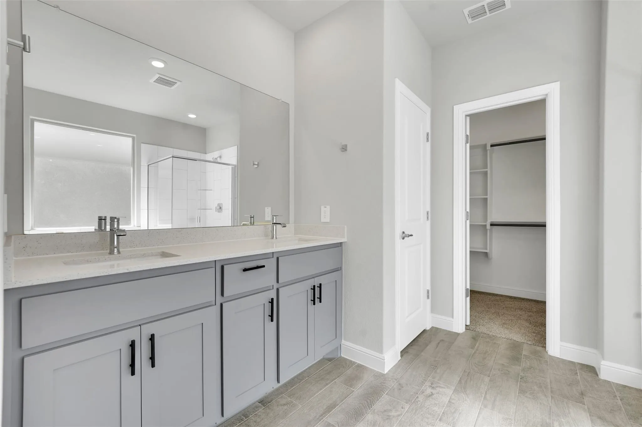 Dual vanity with light gray cabinetry, light-toned countertops, and undermount sinks