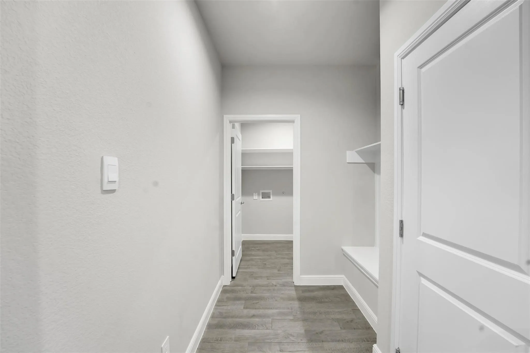 Hallway with wood-finish flooring and light gray walls