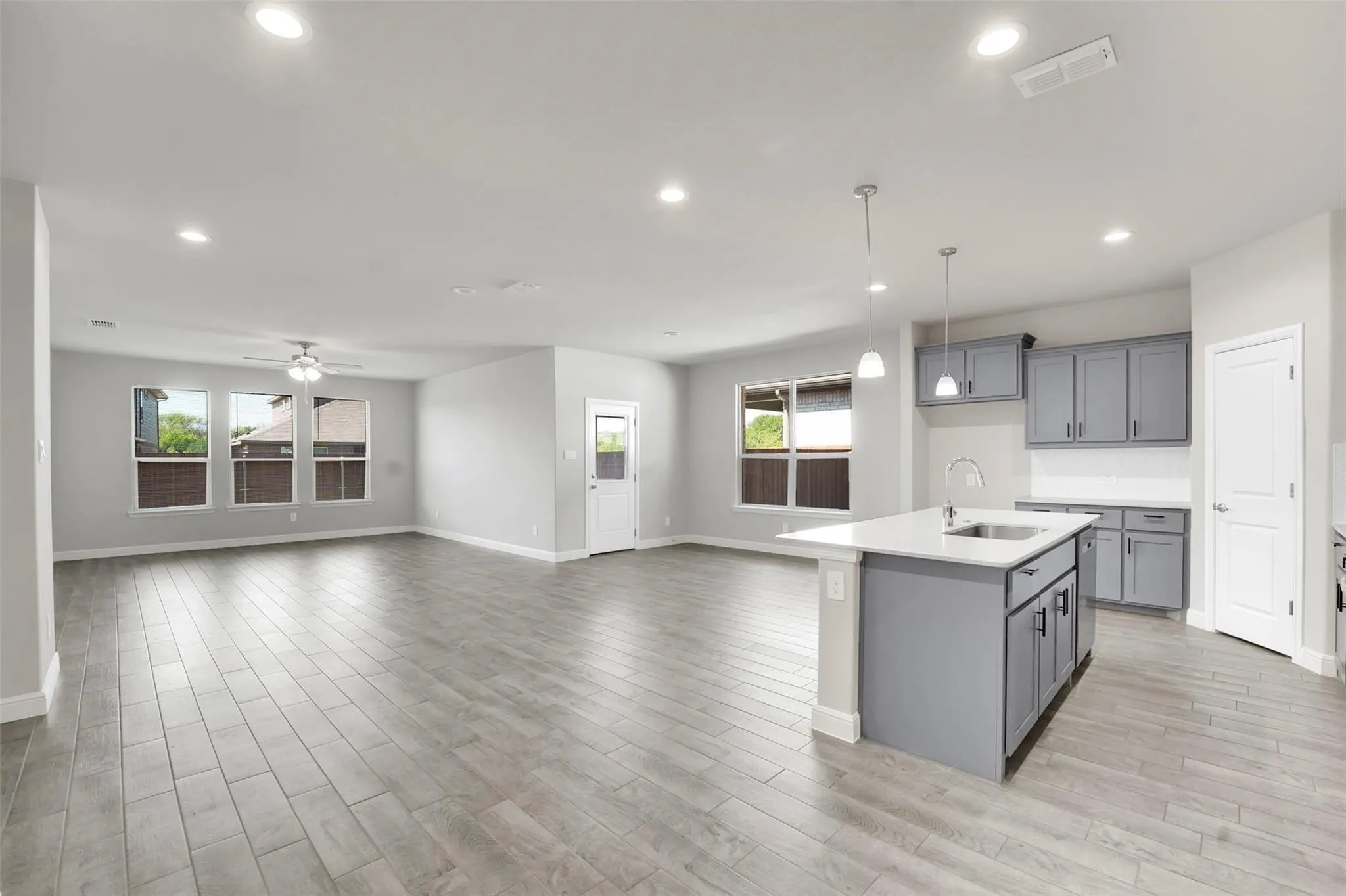 Open-concept living area featuring wood-finish flooring, recessed lighting, and a ceiling fan