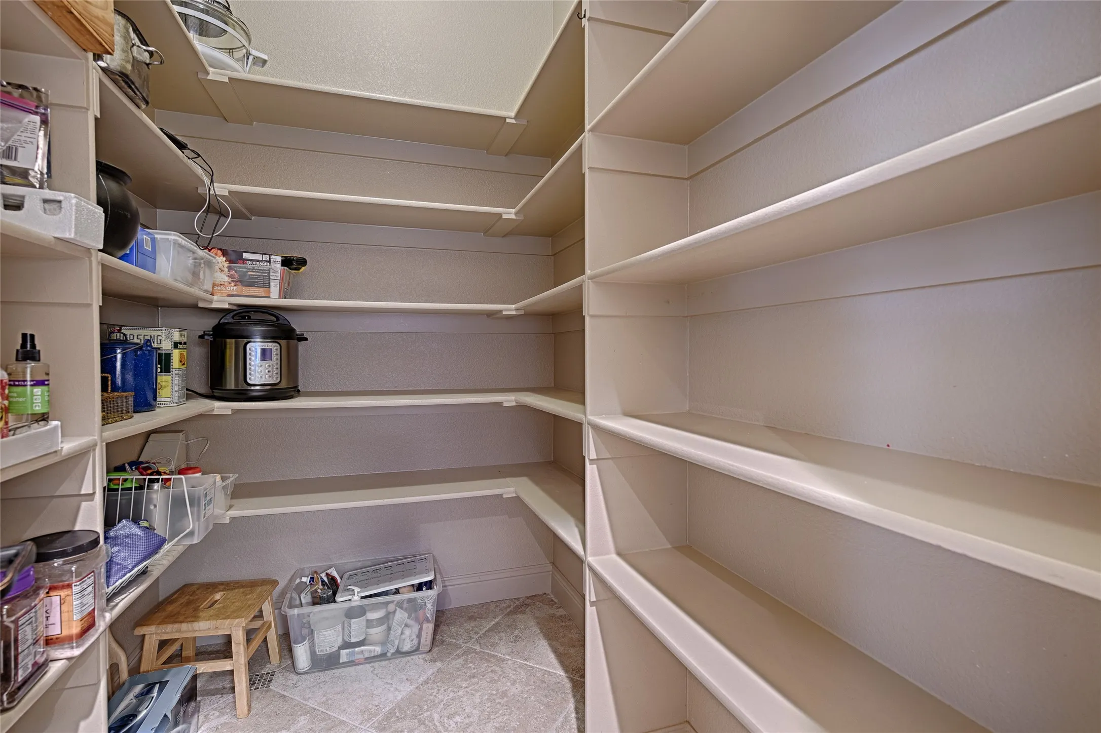 Walk-in pantry featuring expansive shelving and tile flooring