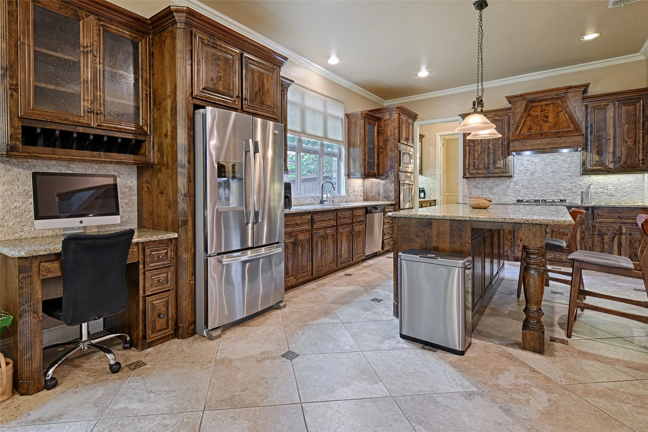 Kitchen featuring wood cabinetry, stainless steel appliances, a central island with a granite-style countertop, recessed lighting, and tile flooring