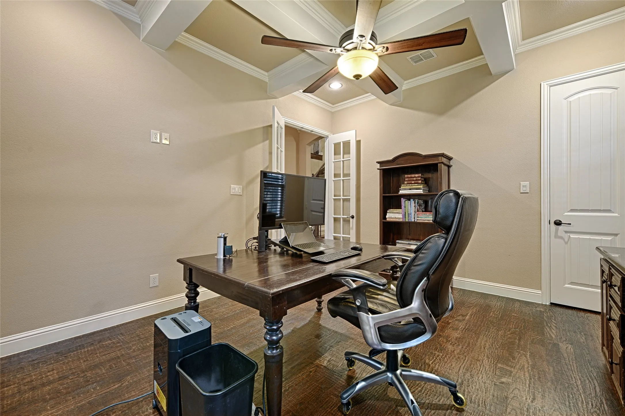Room featuring wood-finish flooring, a coffered ceiling with a ceiling fan, and painted walls