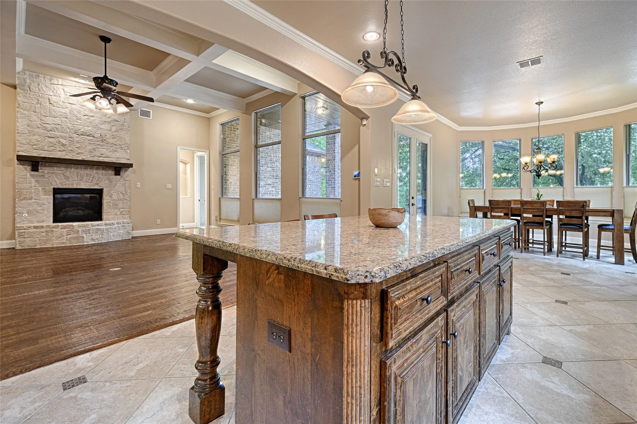 Expansive kitchen island with a granite countertop and detailed wood cabinetry