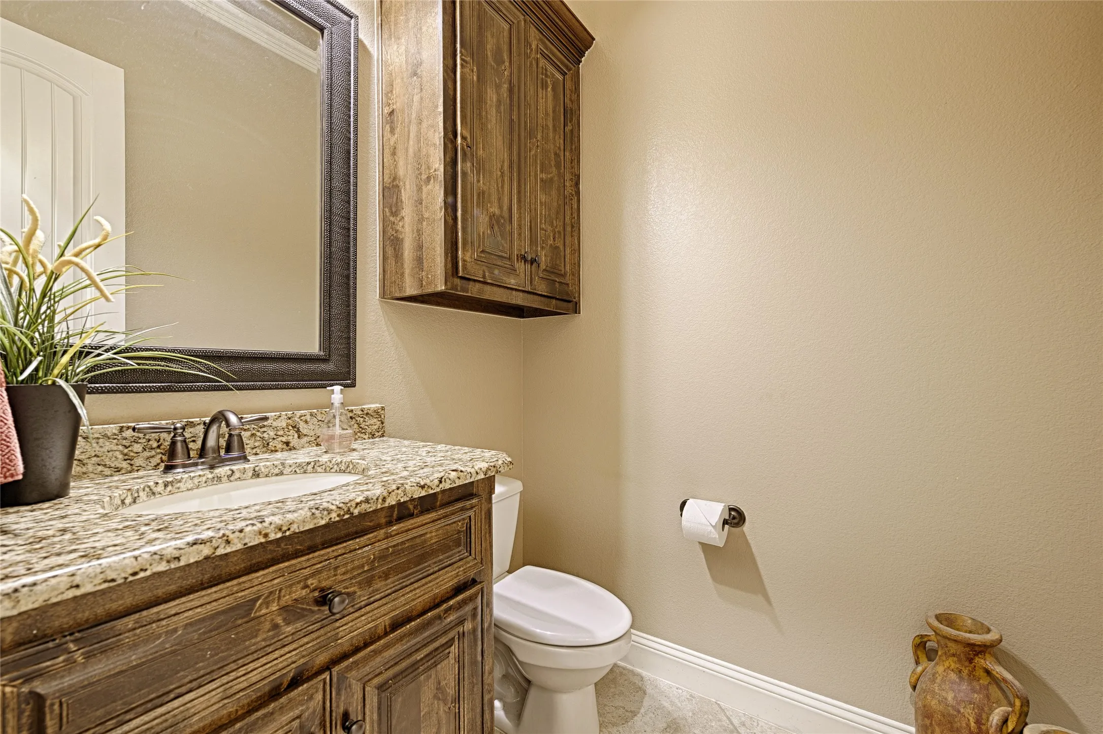 Bathroom featuring a wooden vanity with a granite countertop, undermount sink, and oil-rubbed bronze fixtures