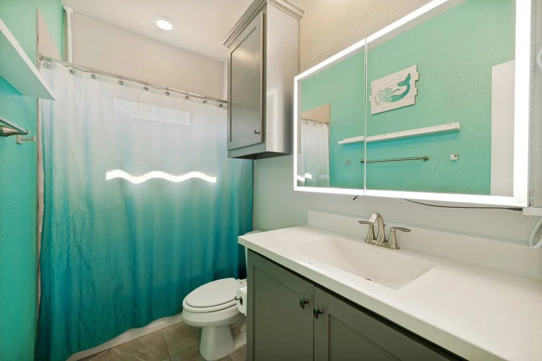 Bathroom featuring a vanity with an integrated sink, brushed nickel faucet, and a lighted medicine cabinet