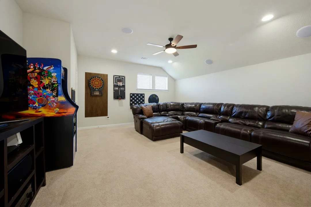 Spacious media/ game room featuring vaulted ceilings, recessed lighting, a ceiling fan, and carpeted flooring