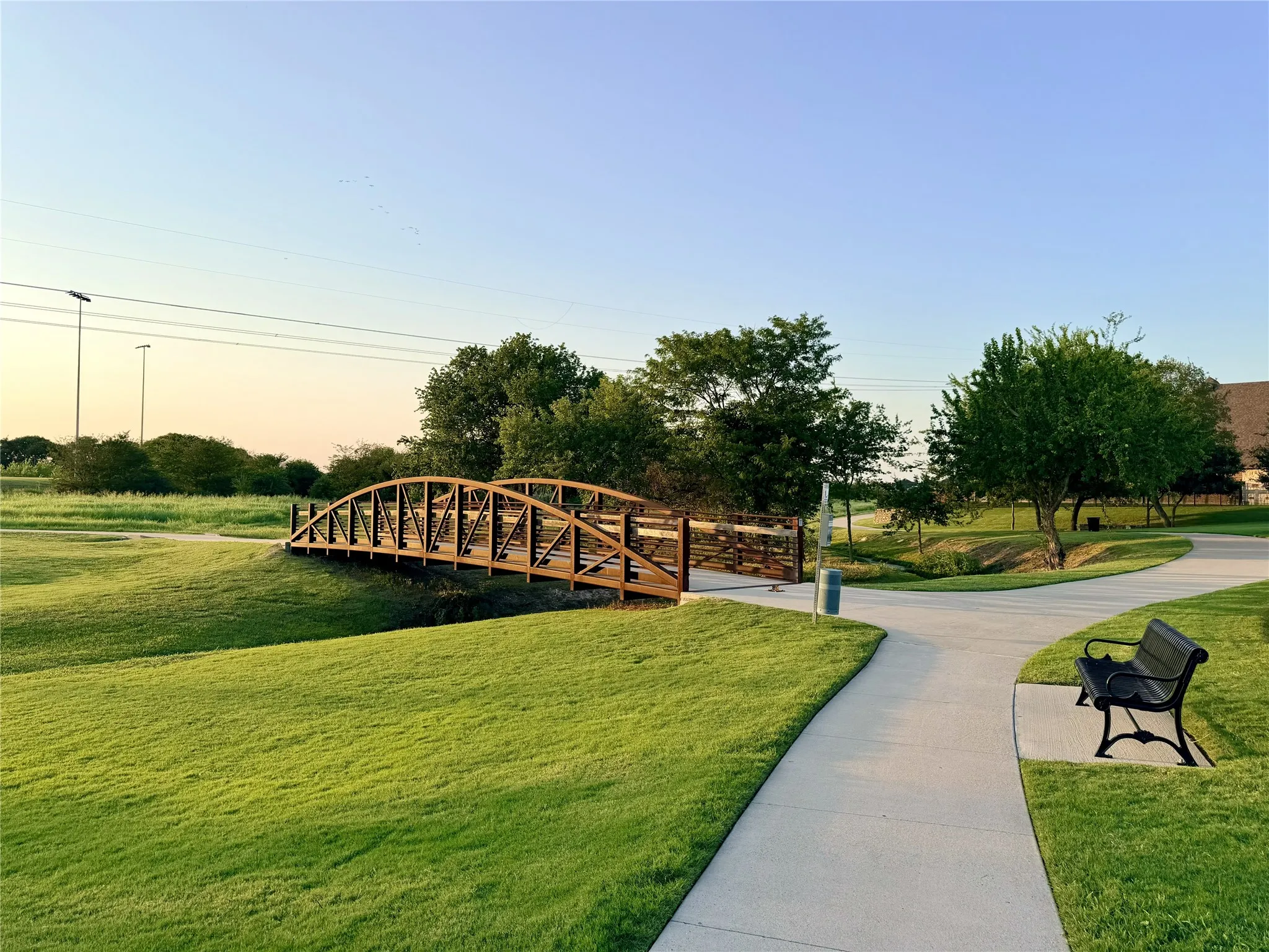 Community Paved pathways featuring a pedestrian bridge and surrounding green space