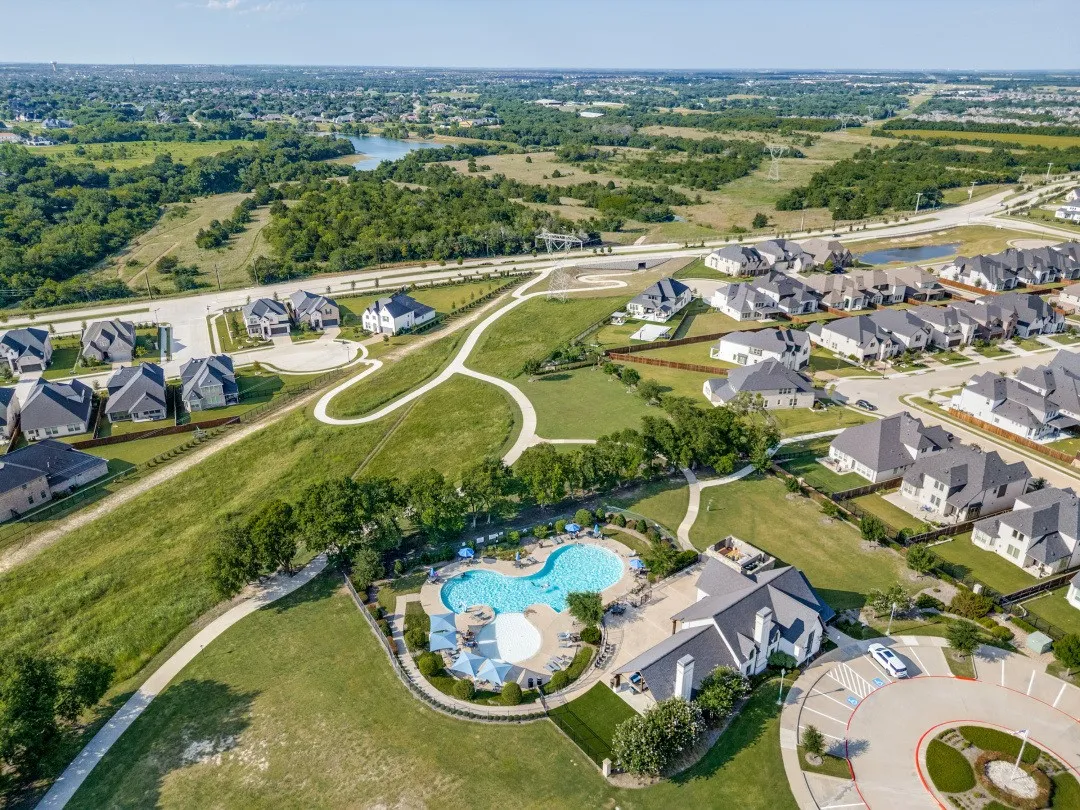 Community development featuring residential properties, recreational building, and two swimming pools surrounded by green space with walking paths