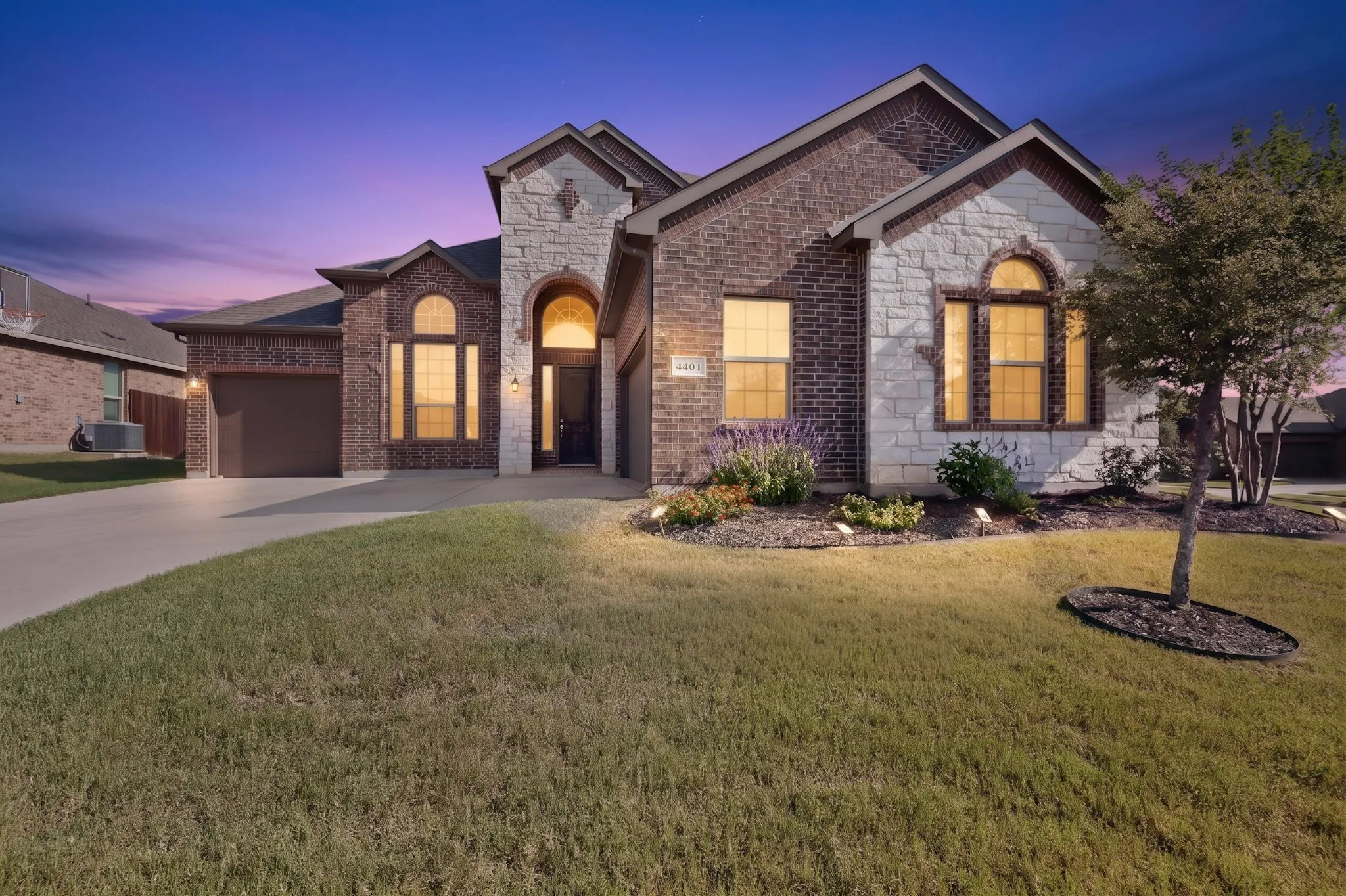 Brick and stone facade featuring arched window elements and an arched entry
