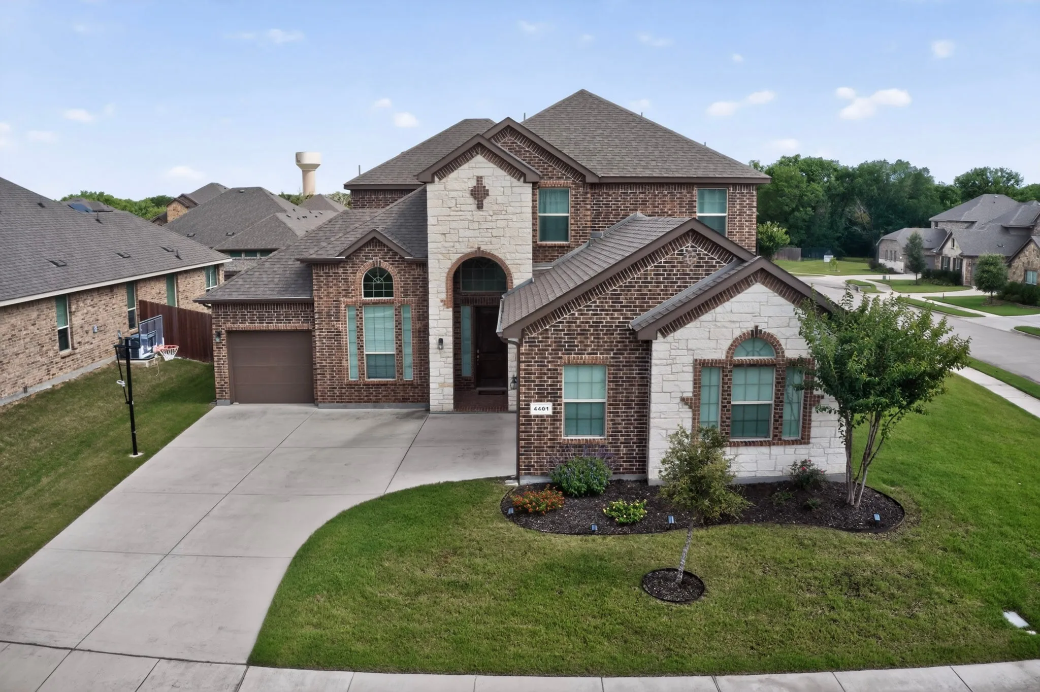 Brick and stone exterior featuring an arched entryway and covered porch