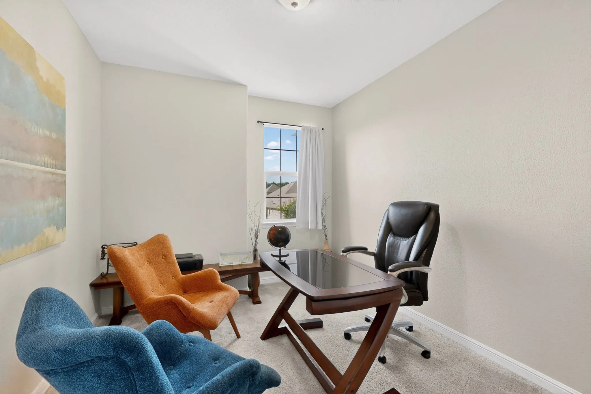 Carpeted room with a single window, textured walls, and a ceiling-mounted light fixture