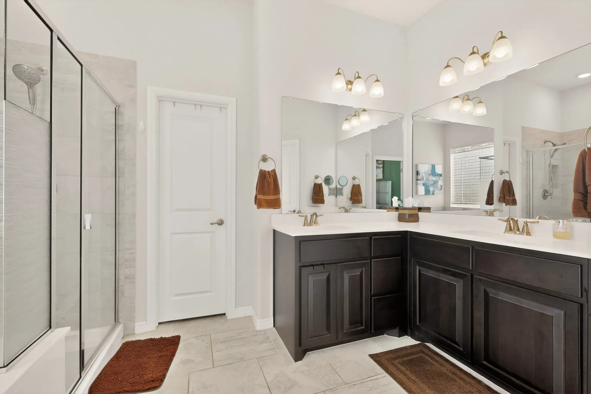 Dual vanity with dark wood cabinetry, white countertops, and bronze-finish fixtures