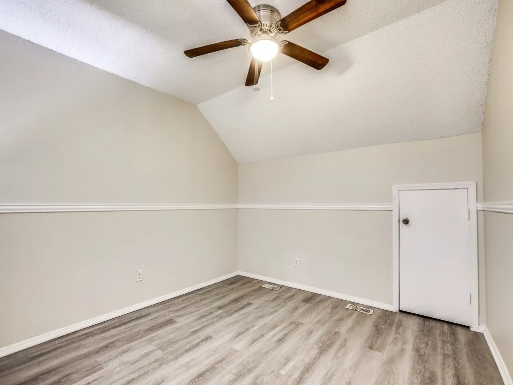 Bonus room featuring ceiling fan, a textured ceiling, lofted ceiling, and hardwood / wood-style floors