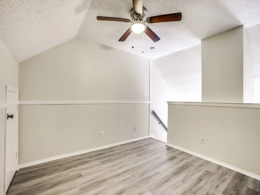 Bonus room with ceiling fan, wood-type flooring, and a textured ceiling