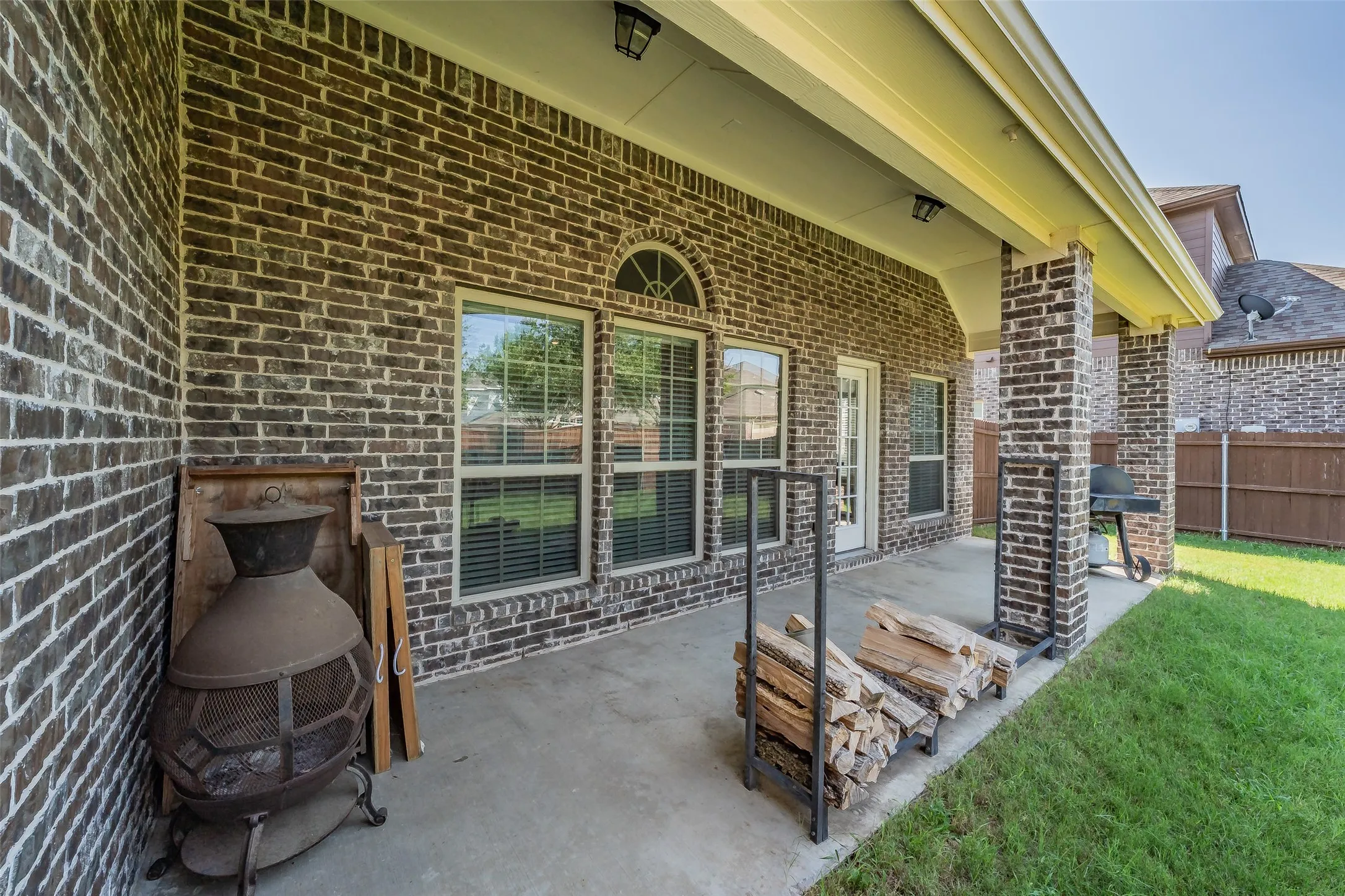 Brick exterior patio featuring a concrete slab, recessed lighting, and a white exterior door