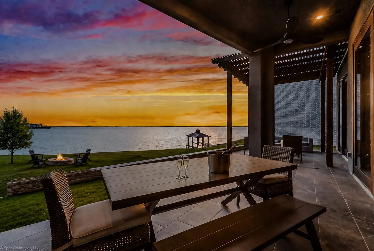 Covered patio featuring slate tile flooring, a dark wood pergola, and a ceiling fan