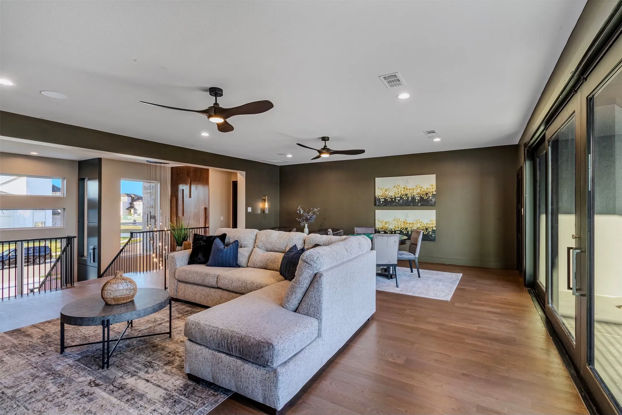 Open-concept living space featuring wood-finish flooring, recessed lighting, and dual ceiling fans