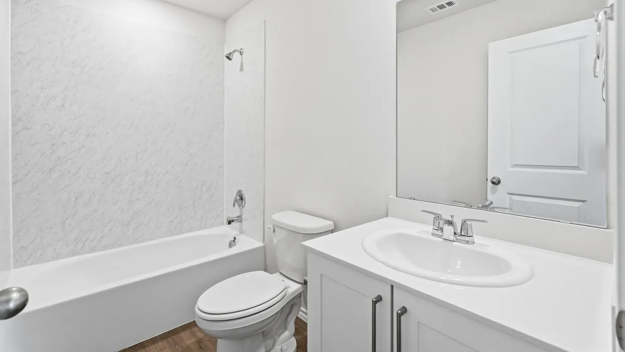 Bathroom featuring a white bathtub, a toilet, and a vanity with a white countertop