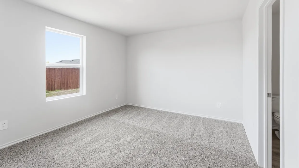 Bright interior space featuring a window with a white frame, light gray carpet, white walls, and white baseboards