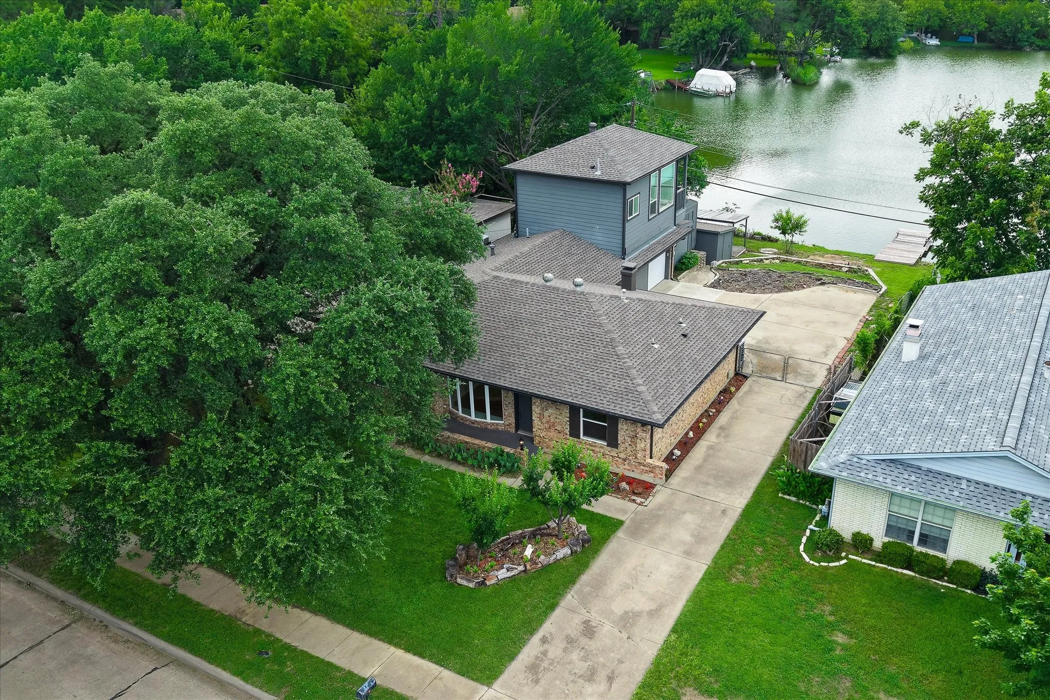 View of front of home, driveway, and view of lake.